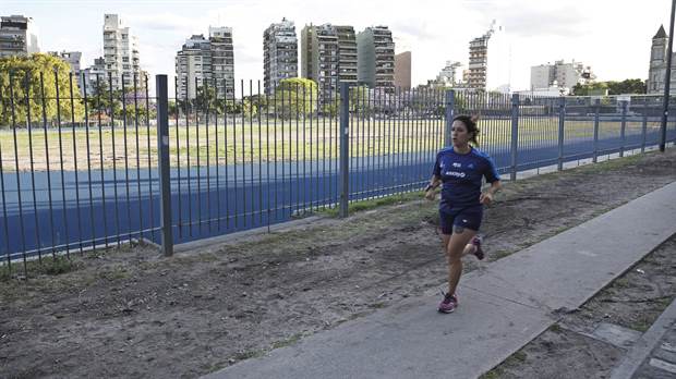 Una deportista amateur corre por el perímetro del Parque Chacabuco mientras aguarda la pista sintética