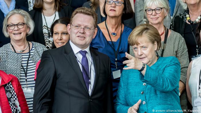 Angela Merkel y el alcalde de Altena durante la entrega del premio de integración alemán.