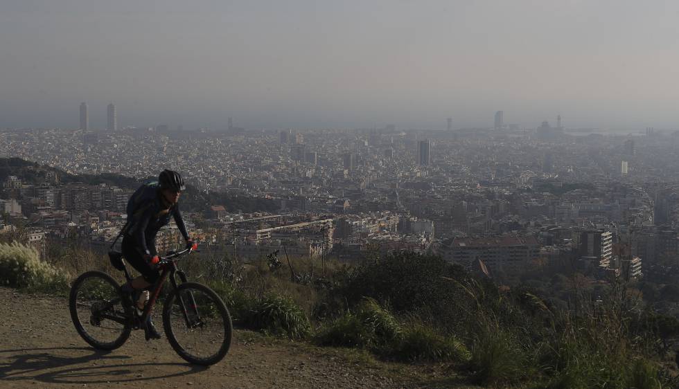 Una ciclista por la carretera de les Aigües (Barcelona) durante un episodio de contaminación
