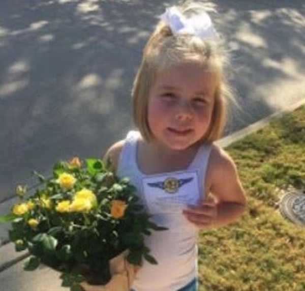 Hadley Shilson, de 5 años, amiga de la familia Damm entrega flores a su vecino (Cortesía de Tyra Damm / The Washington Post)