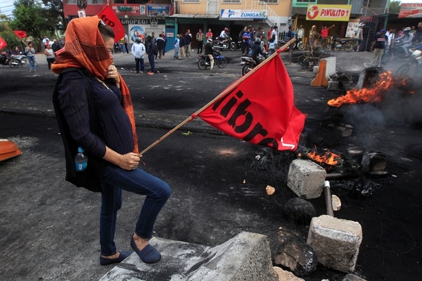 Una militante de la oposición protesta en las calles de Tegucigalpa  por el supuesto fraude en las elecciones presidenciales. (REUTERS/Jorge Cabrera)