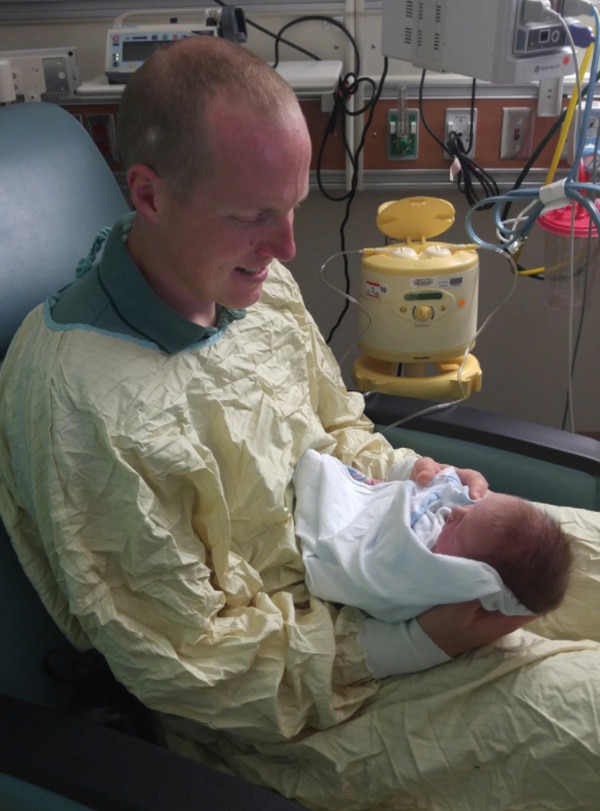 Ryan Holets saluda a su hija, Hope, en el hospital. Los Holets tienen otros cuatro niños pequeños. (Cortesía de Rebecca Holets)