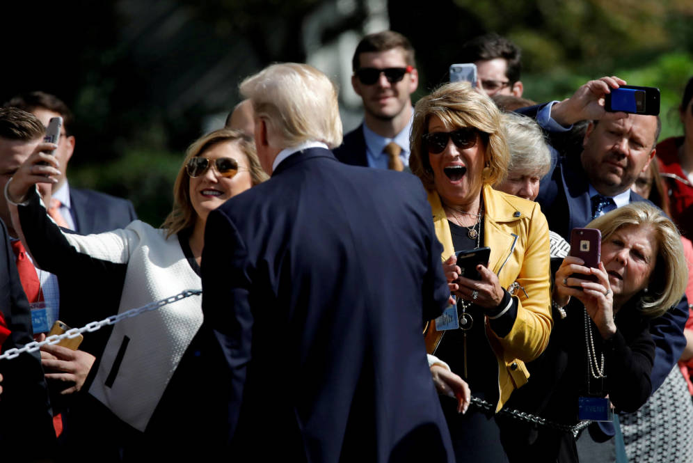 Foto: Visitors react as U.S. President Donald Trump poses for a picture as he departs the Oval Office of the White House for Dallas, in Washington D.C.