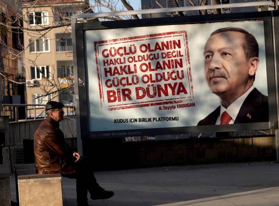 Un hombre se sienta frente a un cartel con la imagen del presidente turco, Recep Tayyip Erdogan, en Gaziantep (Turquía), en diciembre de 2017. (EFE)
