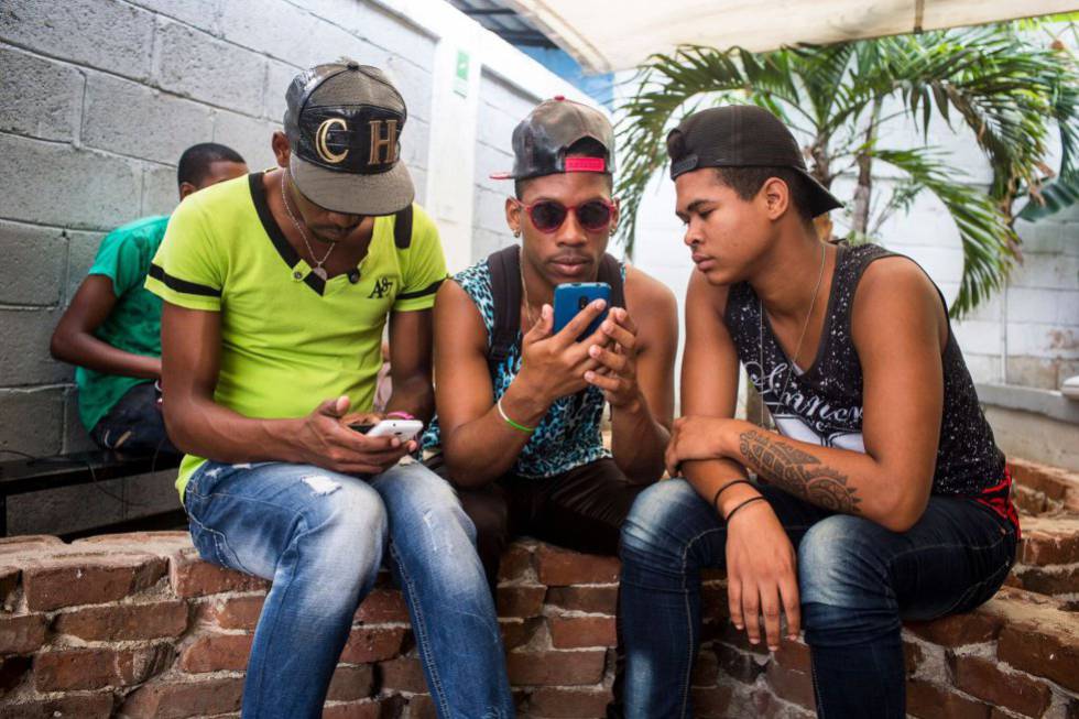 Tres jovenes en La Habana conectados al Wi-Fi con sus móviles en 2016.
