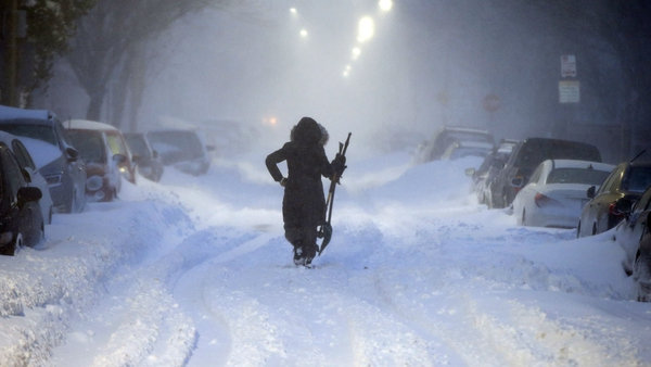Una mujer camina en una calle de Boston durante el ciclón bomba (AP)