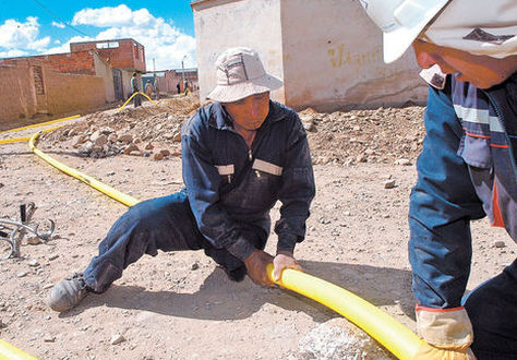 Obreros trabajan en la instalación de una conexión de gas domiciliario