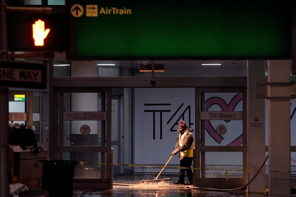 Un trabajador saca el agua de la terminal 4 del aeropuerto (REUTERS/Andrew Kelly)
