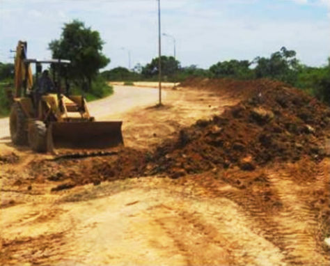 Un tractor remueve tierra para subir el nivel del terraplén que protege a Trinidad de las inundaciones.