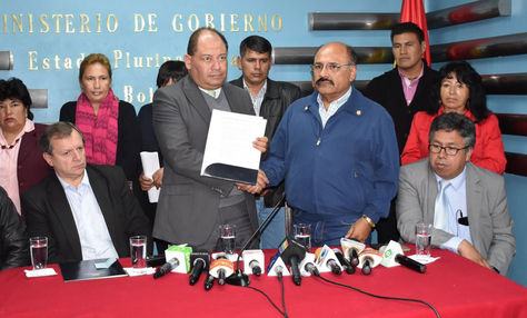Carlos Romero, ministro de Gobierno, y Aníbal Cruz, presidente del Colegio Médico de Bolivia, sellan con un saludo el convenio entre Gobierno y médicos.