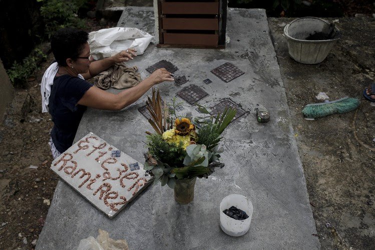 Carmen Cordero, madre de Eliezer Ramirez, decora la tumba de su hijo