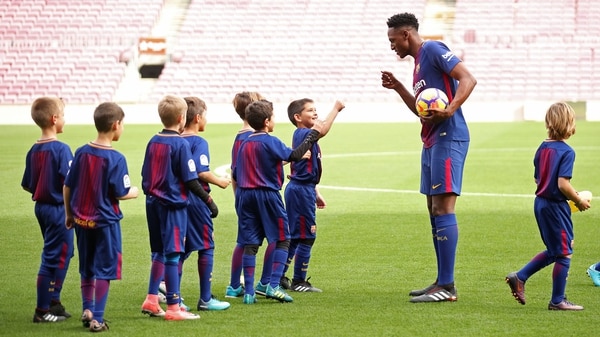 Yerry Mina con los niños de la academia del Barcelona durante su presentación (Reuters)