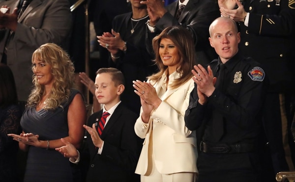 La primera dama, Melania Trump, asistió al primer discurso sobre el Estado de la Unión. En la foto la acompañan Preston Sharp, quien organizó la ubicación de banderas en las tumbas de 40.000 veteranos, y el oficial Ryan Holets de la policía de Albuquerque (REUTERS/Leah Millis)
