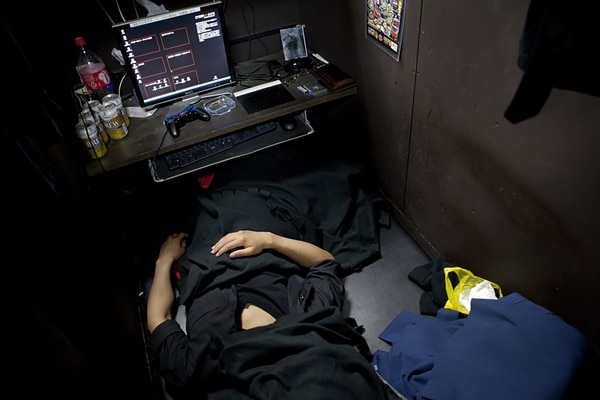 Fumiya, de 26 años, duerme con una manta sobre su cara para bloquear las luces fluorescentes que permanecen encendidas durante la noche. Dice que vivir en un cibercafé “no es tan malo”.