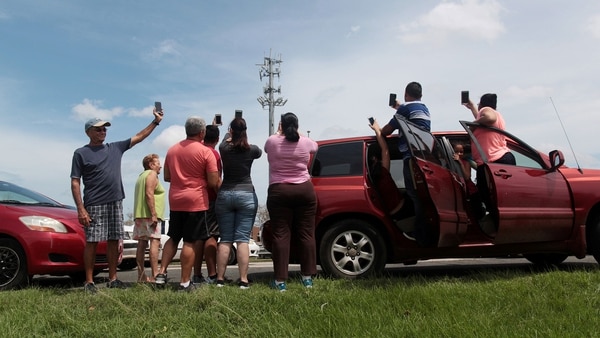 La disponibilidad de celulares sigue siendo limitada en la región, especialmente en las clases bajas. En la foto habitantes de Puerto Rico buscan señal (Reuters)