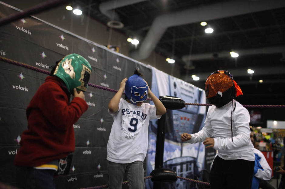 Unos niños se prueban máscaras de lucha libre durante una exposición sobre este deporte en Ciudad de México, en agosto de 2012. (Reuters)