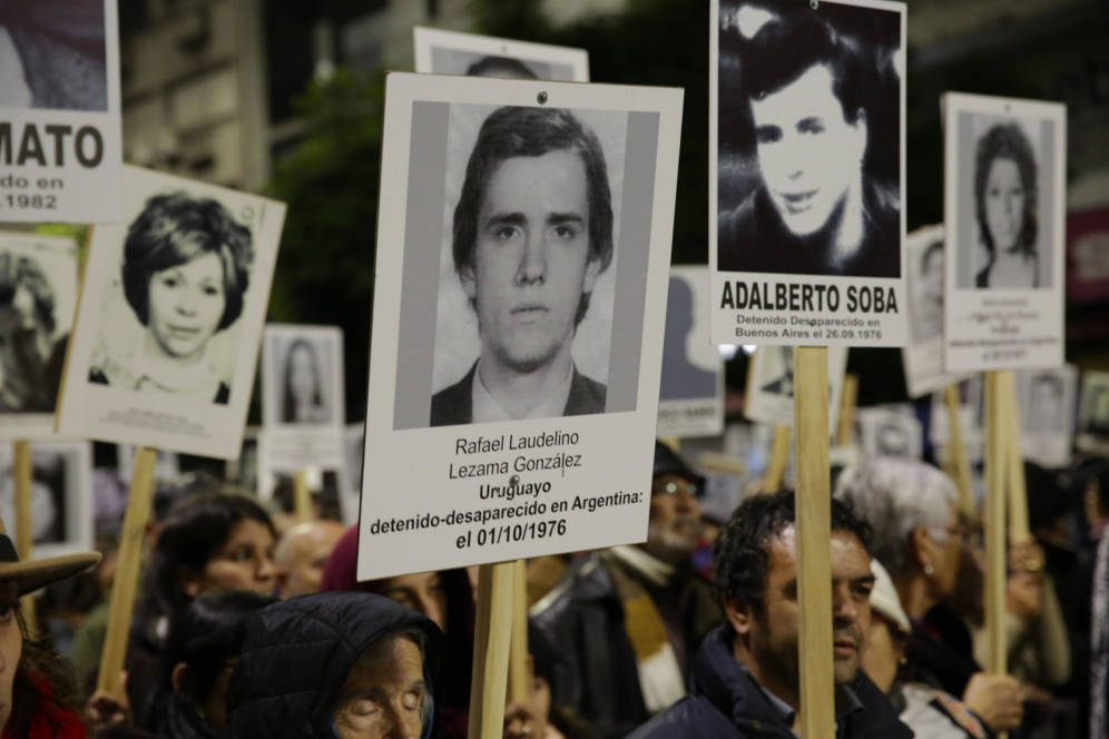 Foto: Manifestantes portan fotografías de detenidos desaparecidos durante la dictadura en una marcha en Montevideo. (EFE)