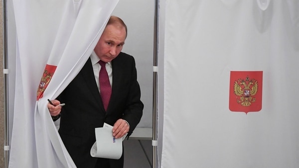 Vladimir Putin rumbo a depositar la papeleta electoral. (Reuters)