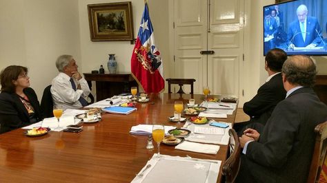 El presidente Sebastián Piñera y sus coleboradores observan en Santiago la exposición del agente Claudio Grossman. Foto: @Minrel_Chile
