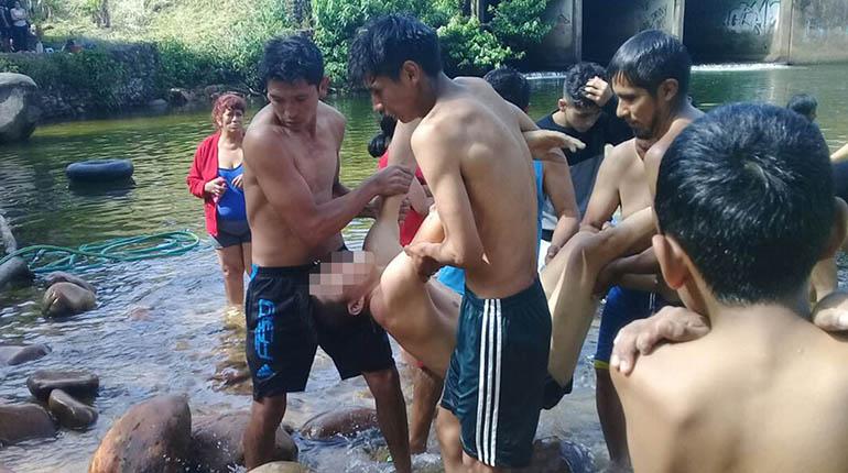 Amigos del joven que se ahogó ayudan a sacar el cuerpo del río. | Trópico te informa