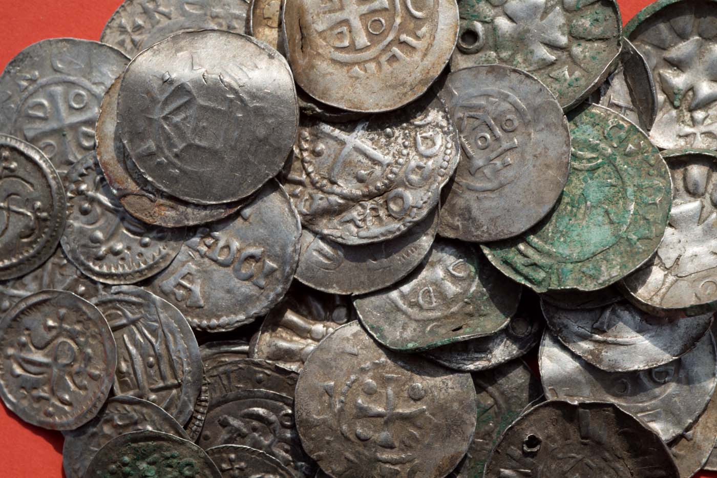 Saxon, Ottonian, Danish and Byzantine coins are pictured on a table in Schaprode, northern Germany on April 13, 2018. A 13-year-old boy and a hobby archaeologist have unearthed a "significant" trove in Germany which may have belonged to the legendary Danish king Harald Bluetooth who brought Christianity to Denmark. A dig covering 400 square metres (4,300 square feet) that finally started over the weekend by the regional archaeology service has since uncovered a trove believed linked to the Danish king who reigned from around 958 to 986. Braided necklaces, pearls, brooches, a Thor