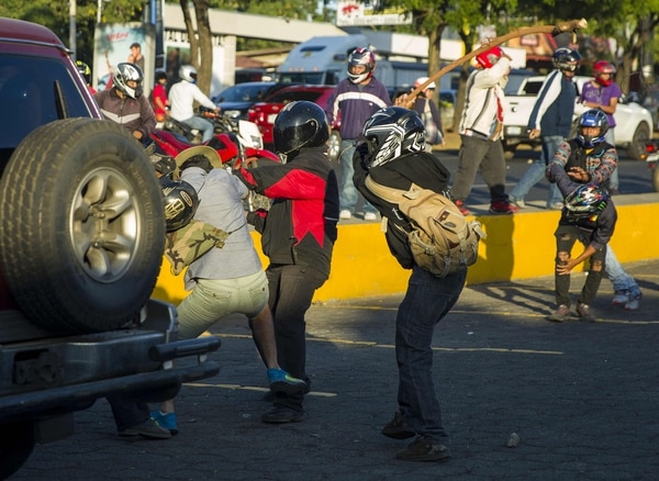 Dos miembros de las fuerzas antichoque agreden a una persona durante las protestas en contra de las reformas del Instituto Nicaragüense de Seguridad Social (INSS), en Managua (EFE/Jorge Torres)