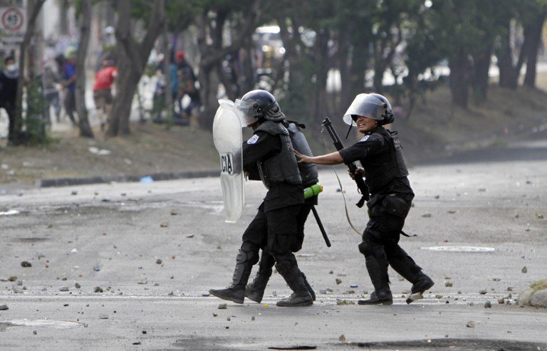Los agentes de la policía antidisturbios se preparan para disparar durante las protestas contra las reformas del gobierno en el Instituto de Seguridad Social (INSS) en Managua el 21 de abril de 2018. AFP PHOTO / INTI OCON