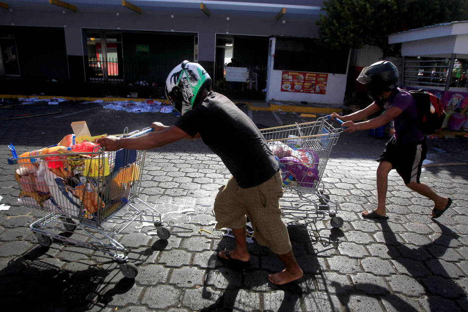 Nicaraguenses con bienes robados de una tienda durante saqueos en Managua, Nicaragua. (Reuters)