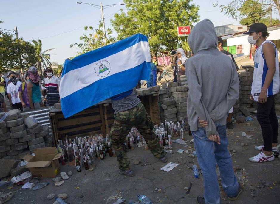 Varios jóvenes protestan el domingo durante el quinto día de manifestaciones en contra de una reforma a la seguridad social, en Managua, Nicaragua. (EFE)
