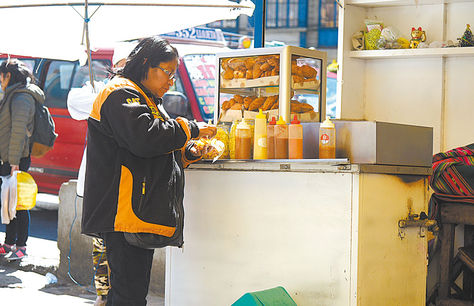 Riesgo. Un ciudadano consume una tucumana en un puesto de la Pérez Velasco.