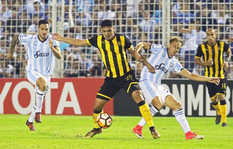 El jugador de Peñarol Gabriel Fernandez disputa un balón con el argentino Nery Leyes.