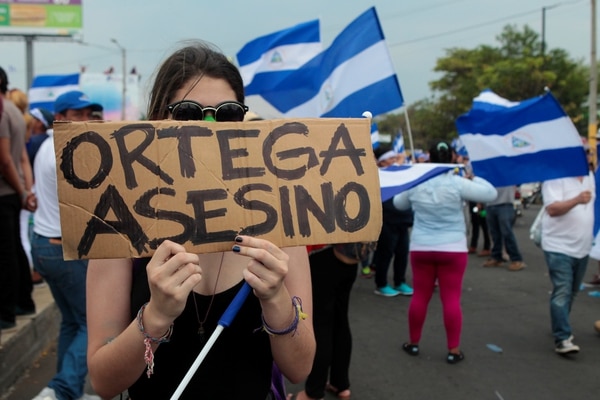 Una manifestante con el cartel “Ortega Asesino” durante una manifestación contra el gobierno este miércoles (REUTERS/Oswaldo Rivas)