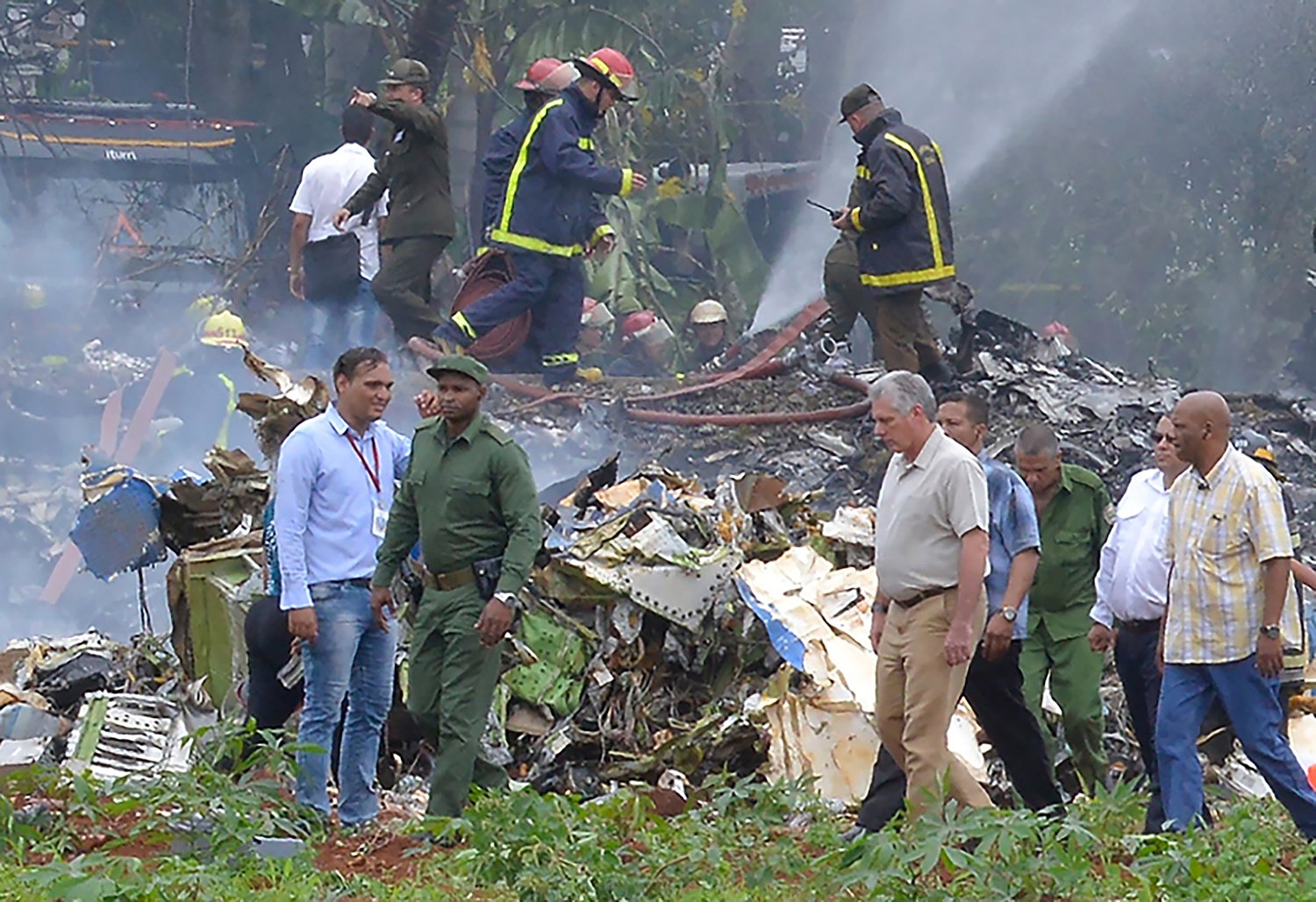 Cuban President Miguel Diaz-Canel (2-R, in khaki) is pictured at the site of the accident after a Cubana de Aviacion aircraft crashed after taking off from Havana