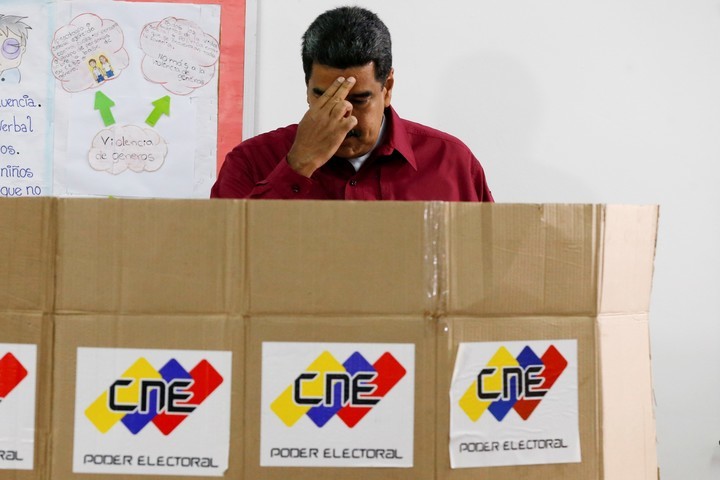 Nicolás Maduro se persigna antes de emitir su voto. AP