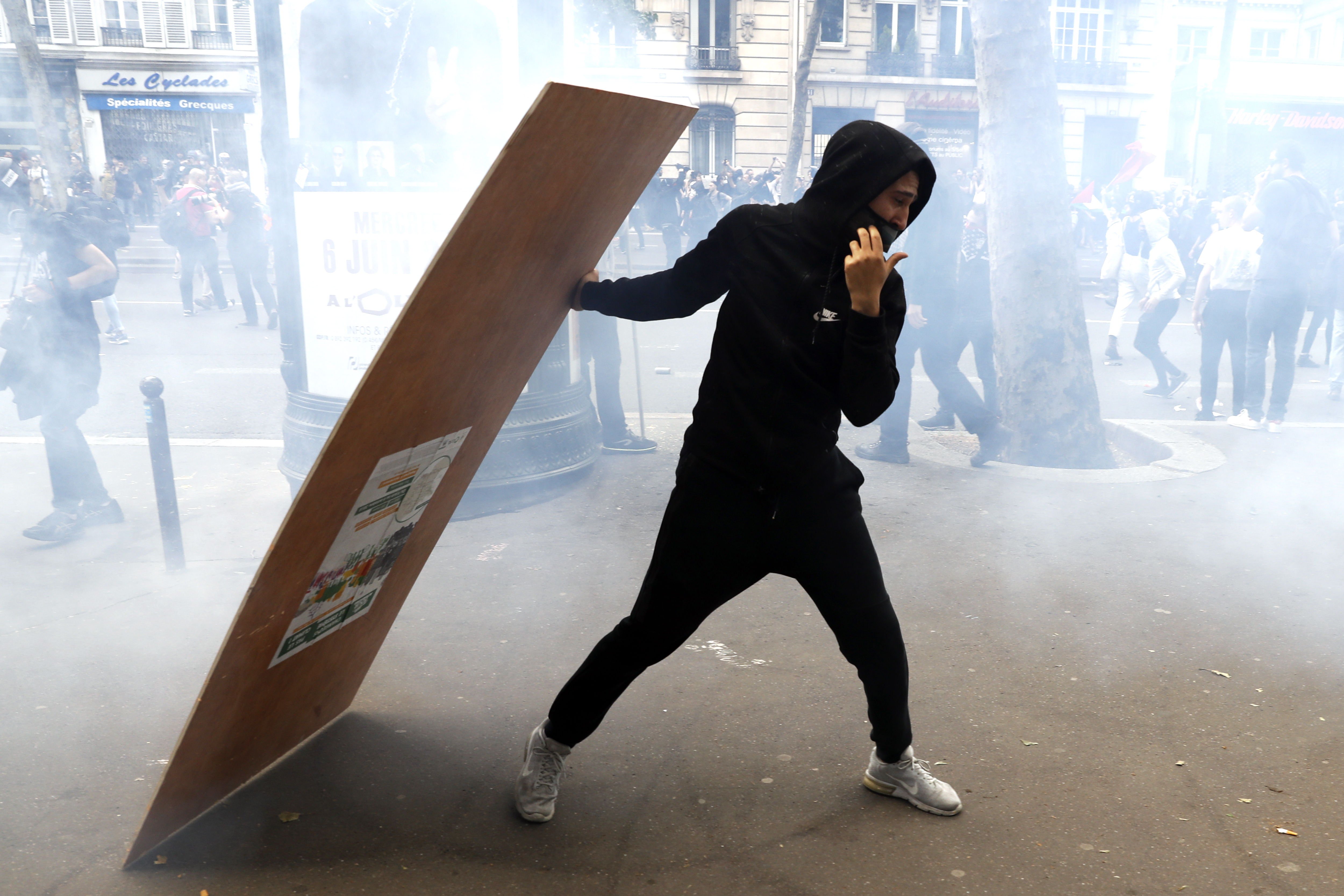 Paris (France), 26/05/2018.- A protester takes cover behind a wooden plank as clashes erupt with the police during a demonstration against French government reforms in Paris, France, 26 May 2018. Far left political parties and French trade union CGT (General Confederation of Labour) call for a national day of protest against the government policies. (Protestas, Francia) EFE/EPA/ETIENNE LAURENT