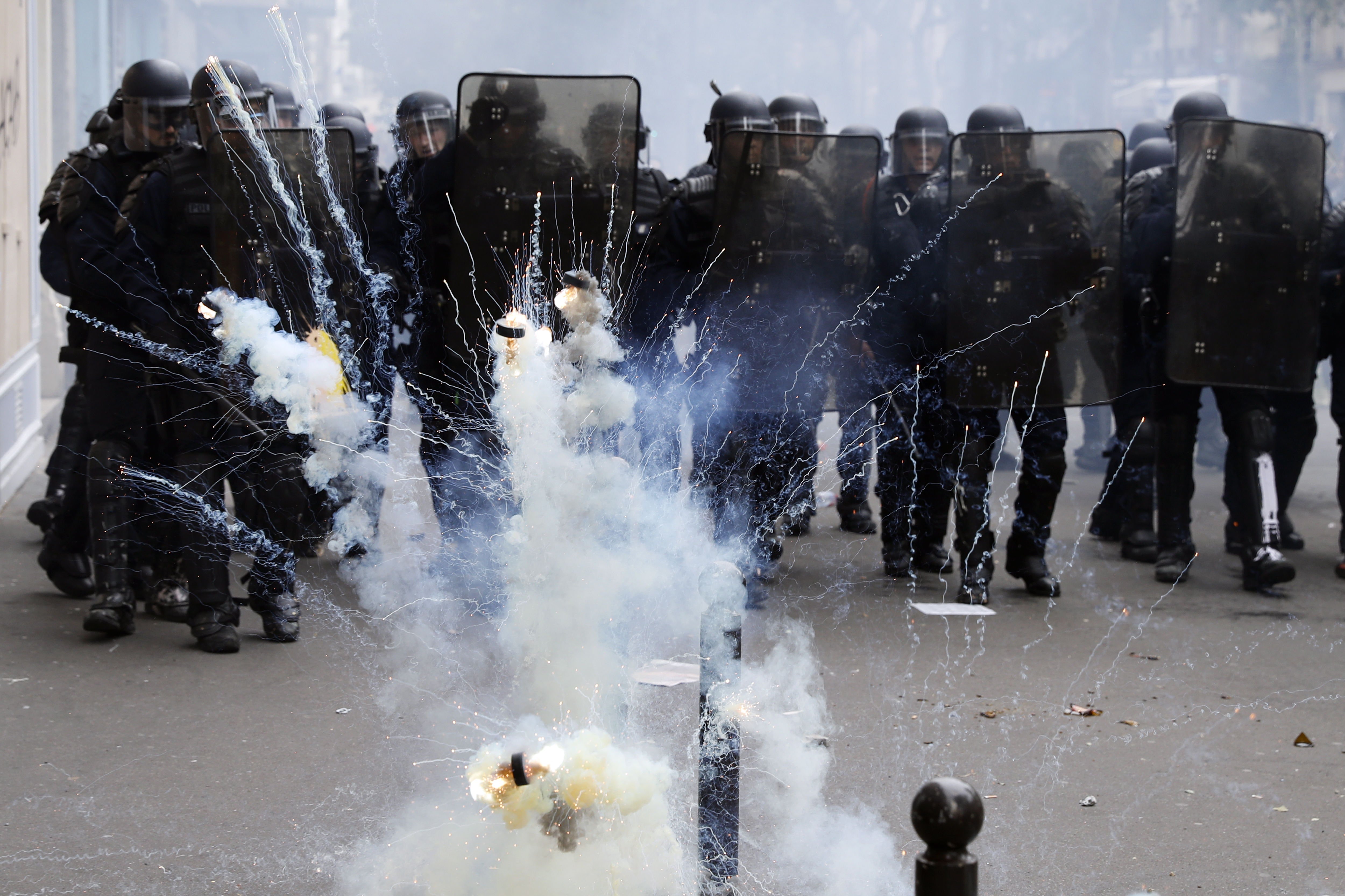 Paris (France), 26/05/2018.- Tear gas palest pucks explode in front of French riot police officers during clashes with a group of protesters as thousands of people demonstrate against French government reforms in Paris, France, 26 May 2018. Far left political parties and French trade union CGT (General Confederation of Labour) call for a national day of protest against the government policies. (Protestas, Francia, Estados Unidos) EFE/EPA/ETIENNE LAURENT