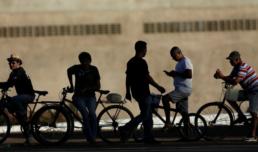 Un grupo de personas esperan con sus bicicletas su turno para echar gasolina en el exterior de una estación de servicio en Brasilia, el 29 de mayo de 2018.
