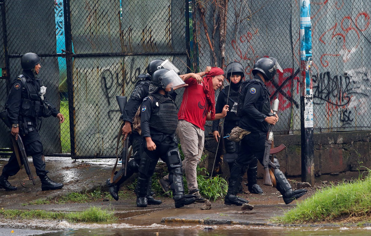 Riot police officers detain a demonstrator during a protest against Nicaragua