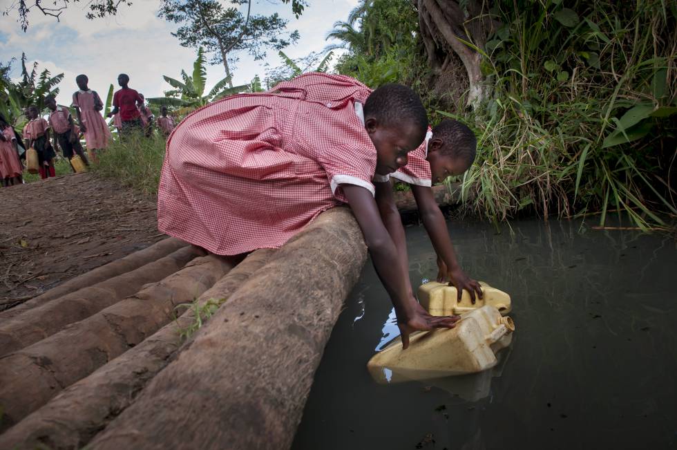 Robina, de 9 años, y su amiga Charity, de 12, recogen agua en Nmamyumba (Uganda).