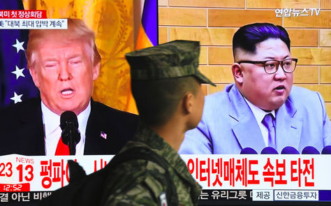Un soldado surcoreano pasa frente a una pantalla de televisión que muestra imágenes del presidente Donald Trump (izq.) y el líder norcoreano, Kim Jong Un, en una estación de tren en Seúl. Foto: AFP