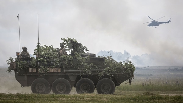 Un vehículo blindado y un helicóptero de la OTAN durante la edición de 2017 de los mismos ejercicios realizados en Polonia y los países bálticos (AFP)