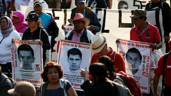 Parientes de los 43 estudiantes de Ayotzinapa durante una marcha para recordar el mes número 29 desde la desaparición de los jóvenes, este domingo en Ciudad de México (Reuters)