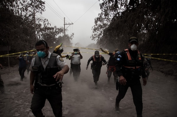 Un grupo de policías de Guatemala ayudan a evacuar a los residentes de la aldea El Porvenir (EFE)