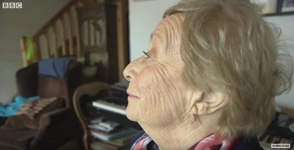Mona maquillada: aunque no puede casi ver, la ayuda su esposo. (Del video de BBC)