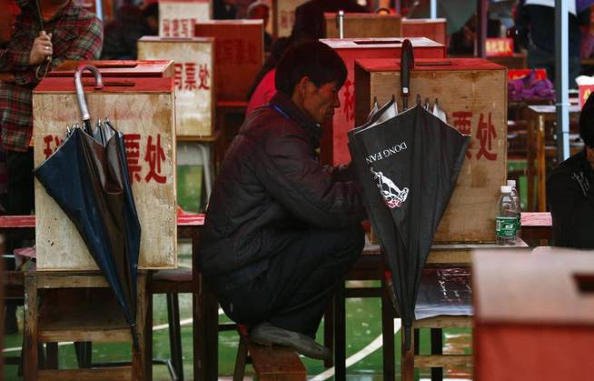 Un hombre, de cuclillas sobre un banco en China. (Reuters)