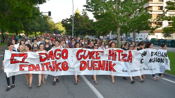 Manifestantes sostienen pancarta en la que se lee “No hay nadie que juzgue nuestro mundo – No es abuso, es violación” (AFP)