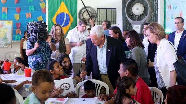 Mike Pence junto a refugiados venezolanos en Brasil (AFP)