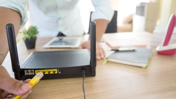 hand and lan network cable with people work on wireless router,