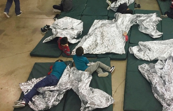 Niños detenidos por intentar entrar al país sin autorización descansan en una de las jaulas en el centro de McAllen, Texas (Oficina de Aduanas y Protección Fronteriza vía AP)