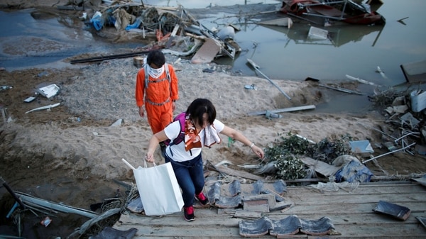 Los residentes locales caminan en un área inundada en la ciudad de Mabi en Kurashiki (REUTERS/Issei Kato)